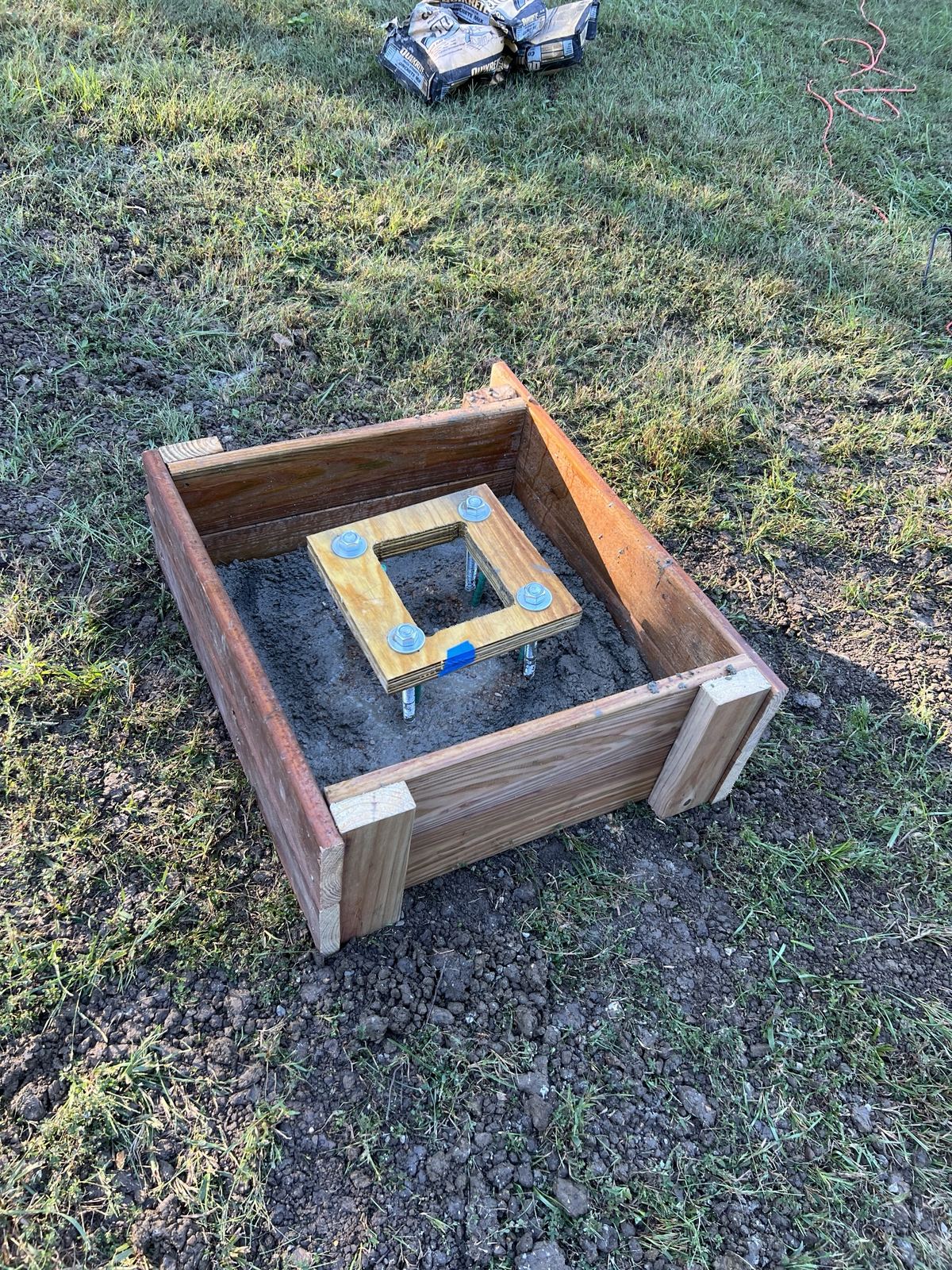 Wooden form with fresh concrete and the anchor-bolt template