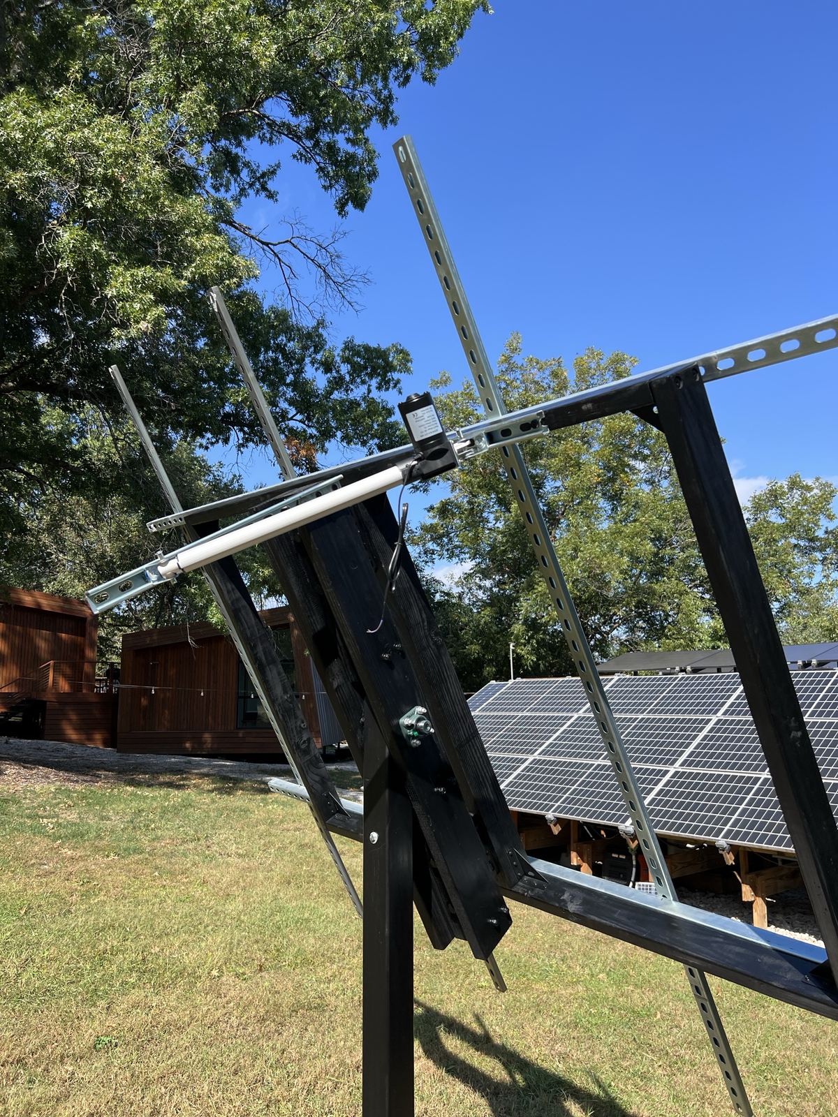 Linear actuator mounted between the mast and the frame
